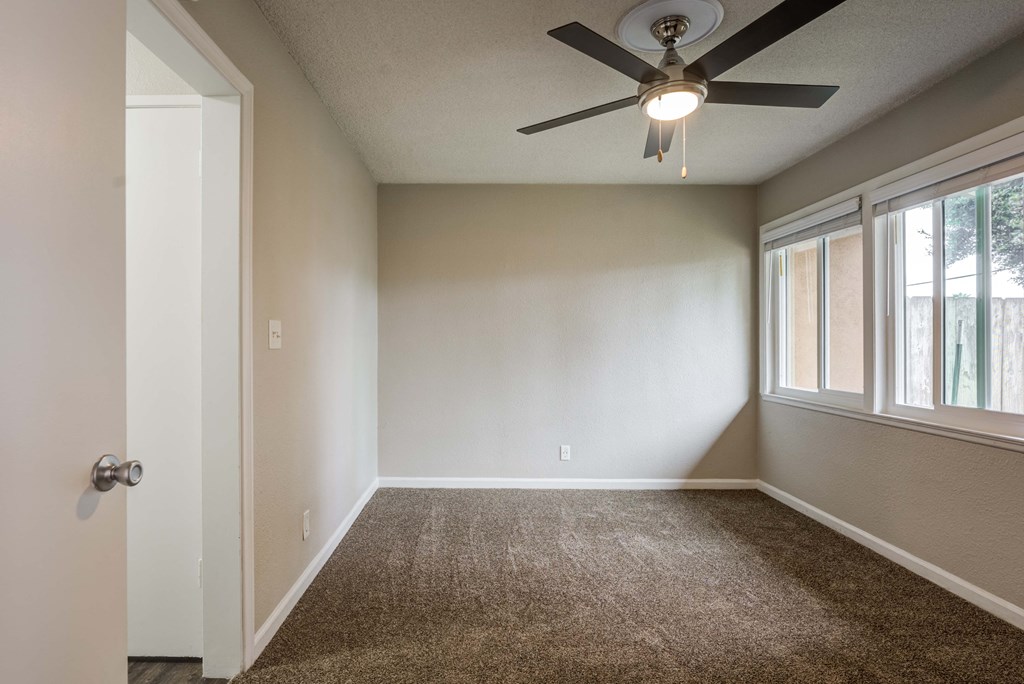 a bedroom with a ceiling fan and a window