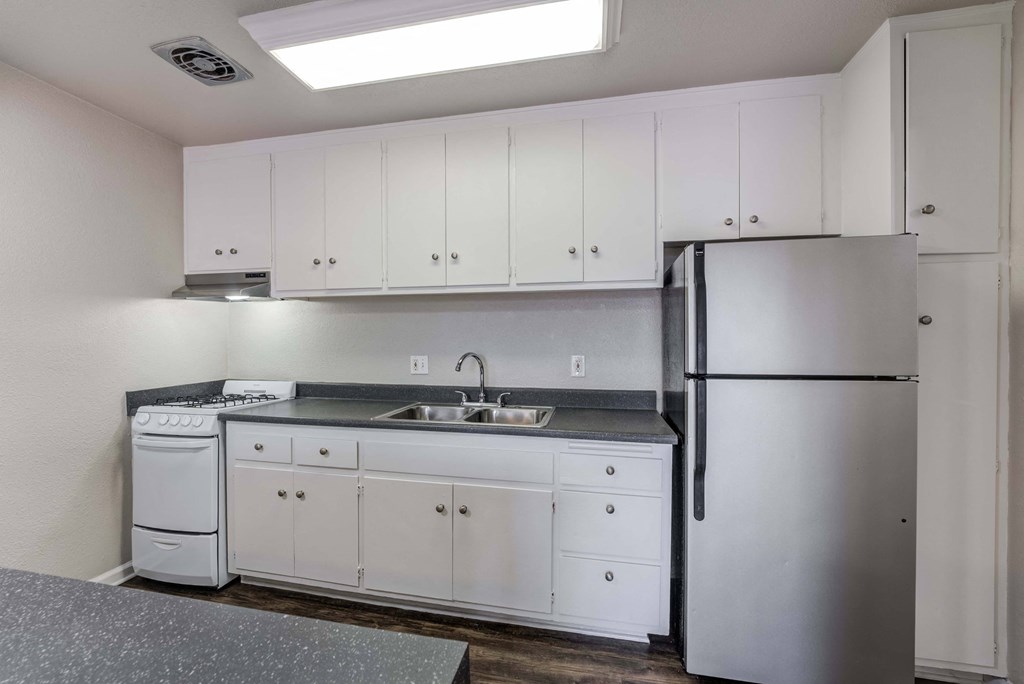 a kitchen with white cabinets and stainless steel appliances