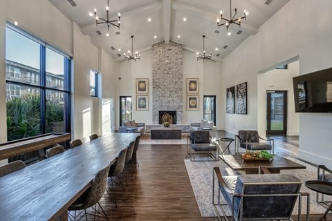 a large living room with a fireplace and a long communal table