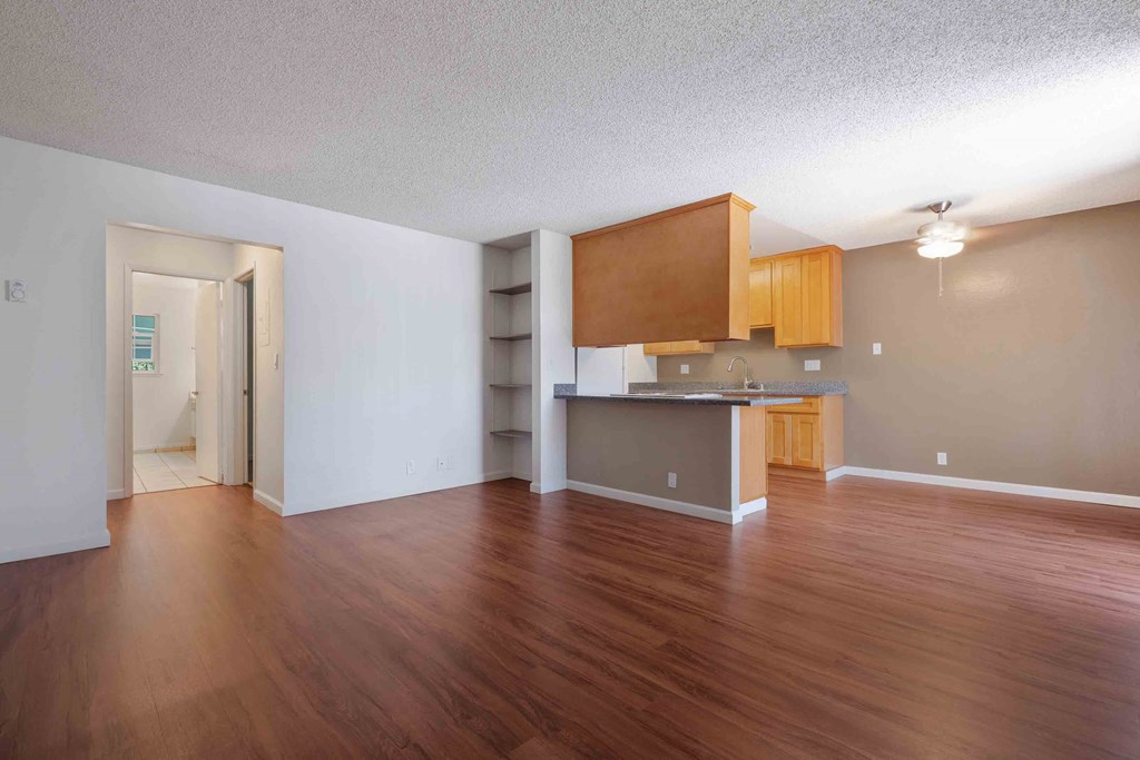 Dog Friendly Apartments in San Jose CA - Village of Taxco - Spacious Living Room with Wood-Style Flooring and Built-In Shelving.