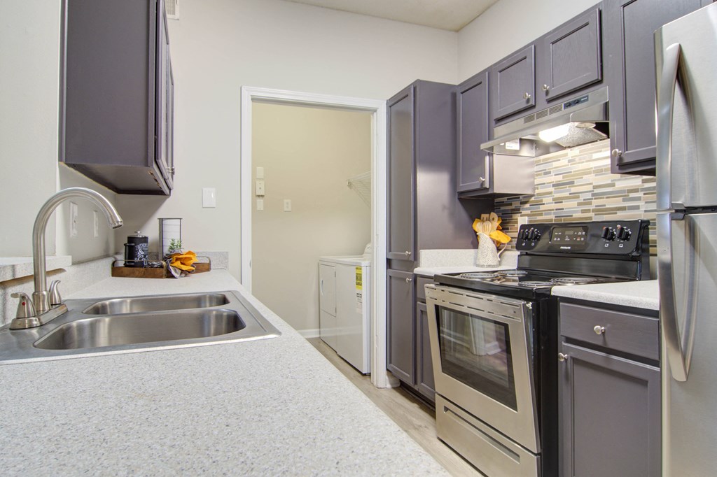 a kitchen with stainless steel appliances and black and white cabinets