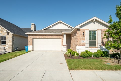 a house with a driveway and a garage door in front of it