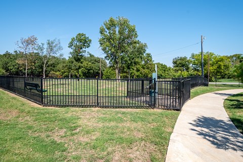 a park with a fence and a sidewalk