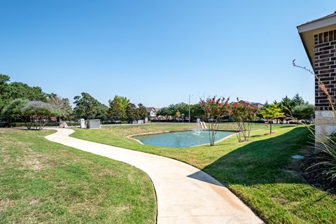 a yard with a pool and a house with grass and trees
