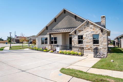 the front of a house with a driveway and a parking lot