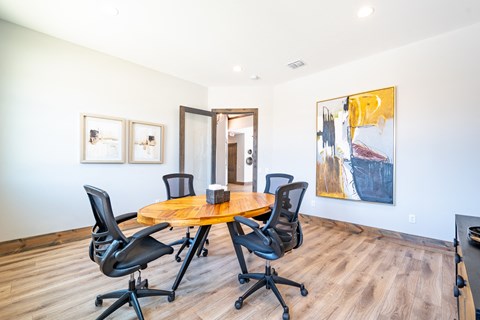 a conference room with a table and chairs and paintings on the wall