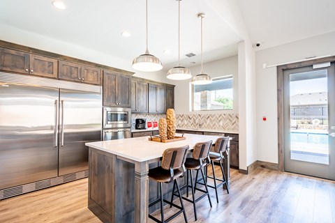 a kitchen with stainless steel appliances and a large island with stools