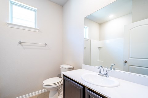 a bathroom with a toilet sink and mirror
