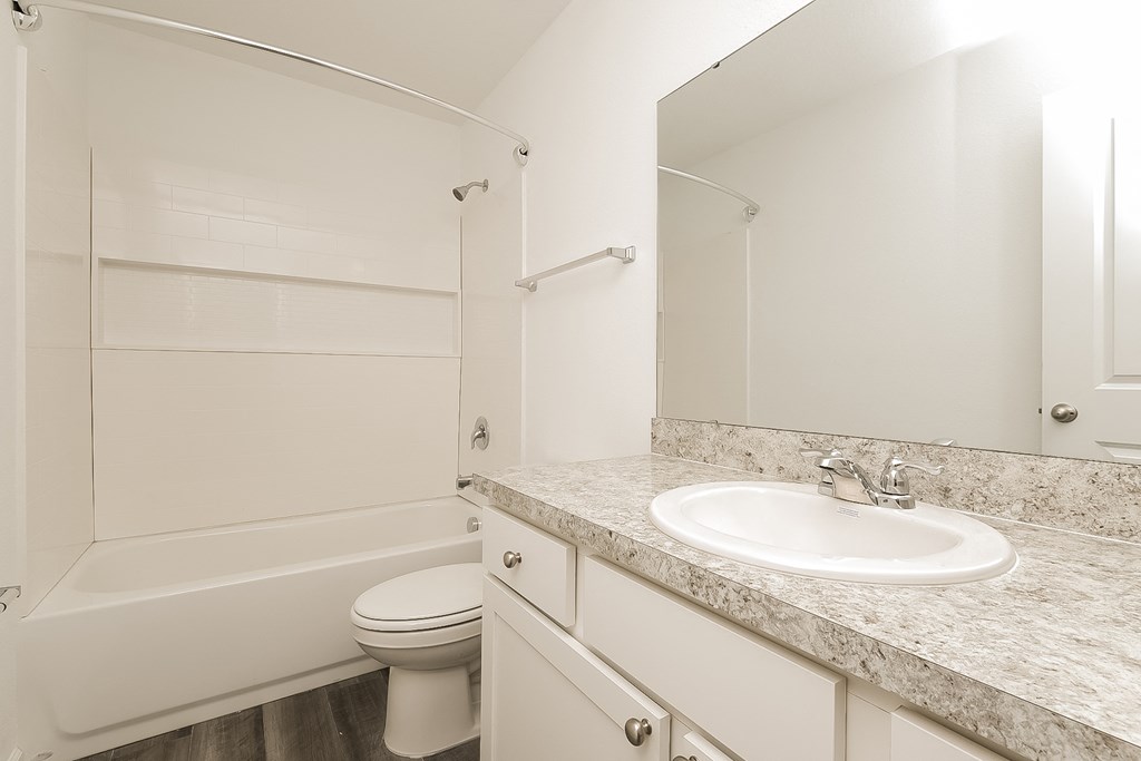 A white bathroom with a sink, toilet, and bathtub.