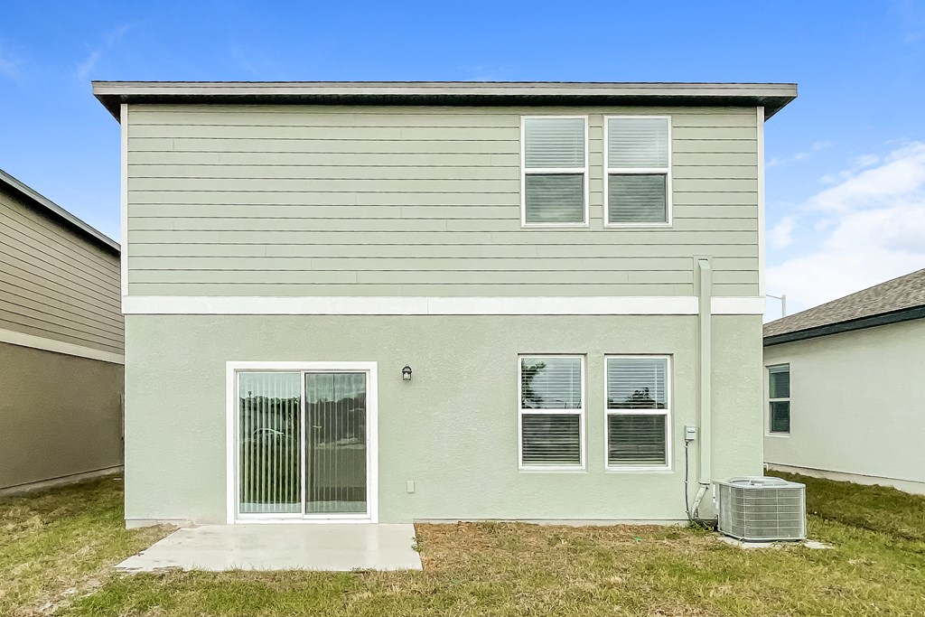 A house with a grey siding and a white door and windows.