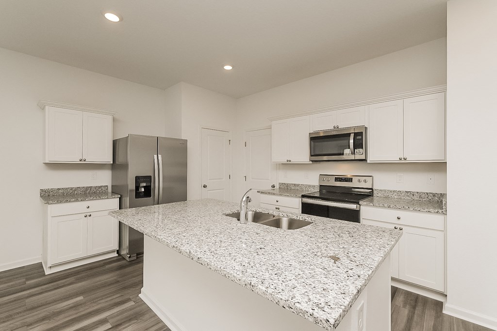 A kitchen with granite countertops and stainless steel appliances.