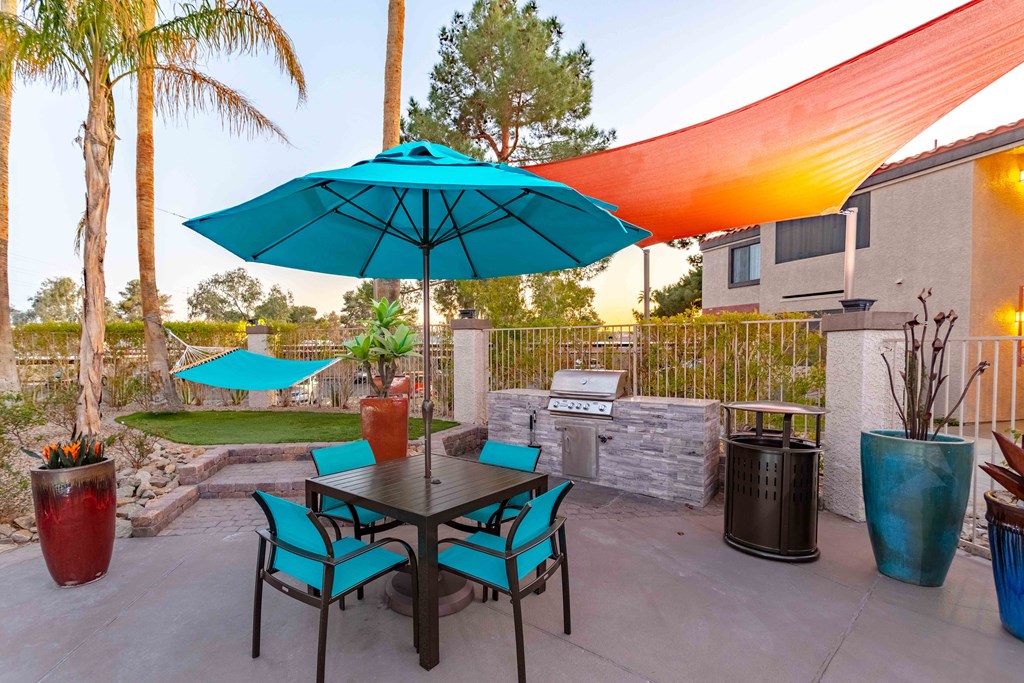 a patio with an umbrella and a table with chairs