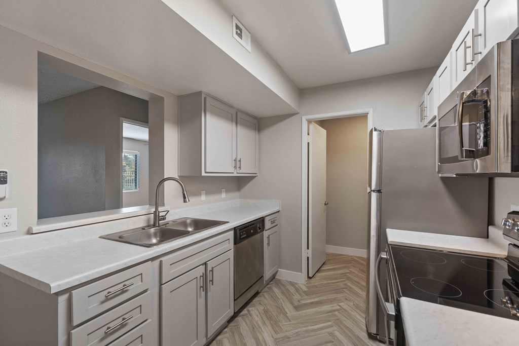 a renovated kitchen with white cabinets and stainless steel appliances