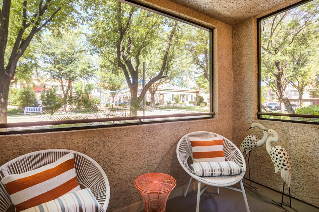 a balcony with two chairs and a large window