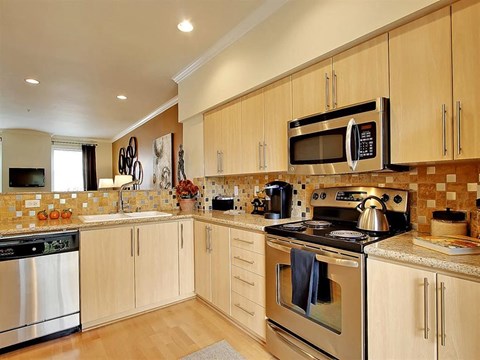 a kitchen with stainless steel appliances and wooden cabinets