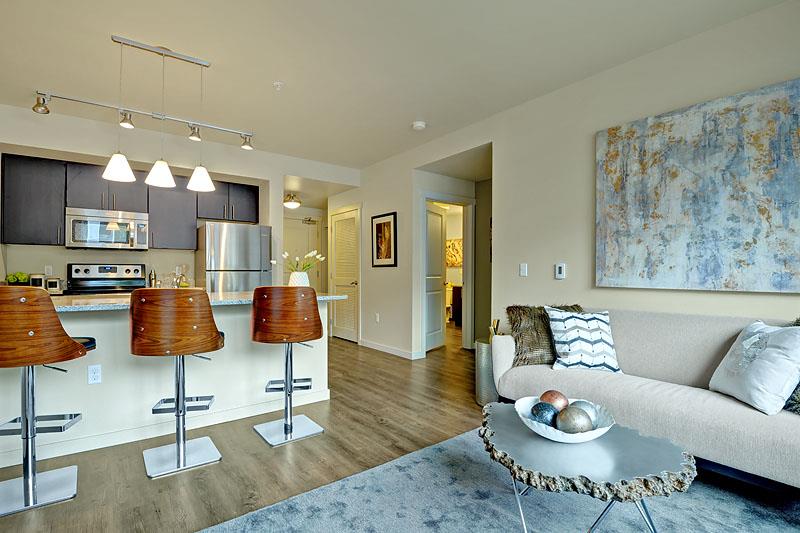 a living room and kitchen with a couch and a table