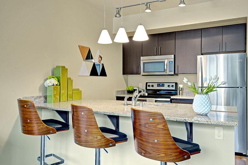1-Bedroom Apartments in Kirkland, WA - Kirkland Crossing - Kitchen with Stainless-Steel Appliances, Granite Counters, Kitchen Island, and Wood-Style Cabinets