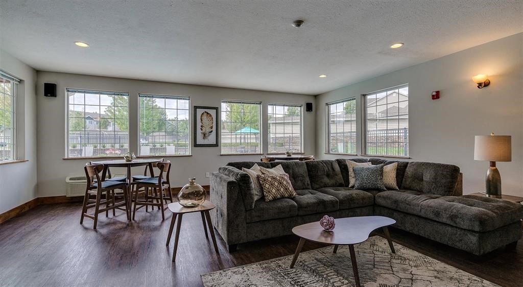 Apartments in Spokane WA - Deer Creek - Clubhouse with Sectional Couch, Circle Dining Table, and Area Rug