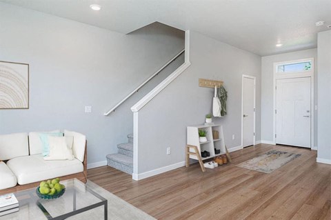a living room with a white couch and a staircase