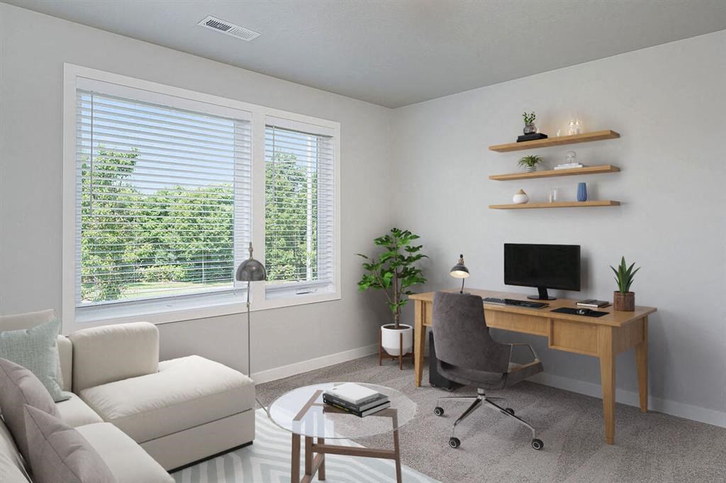 a living room with a couch and a desk with a computer