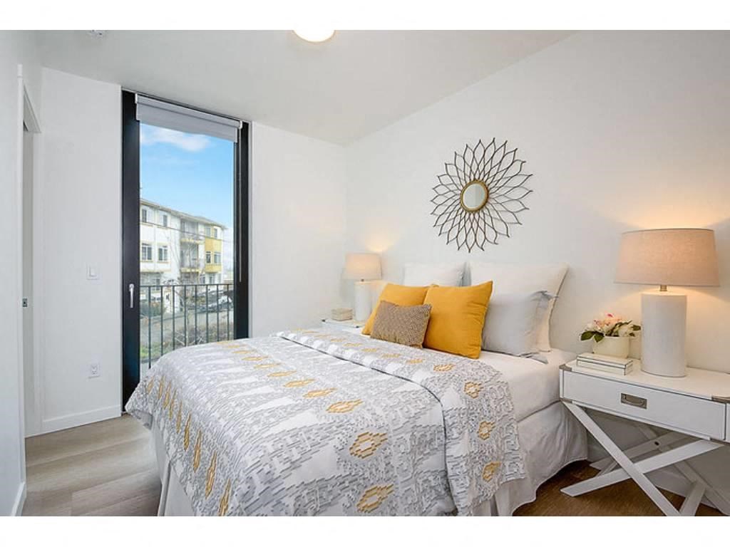 Apartments in Seattle - Inspire Fremont - Bedroom with Hardwood Style Flooring, Glass Door to Private Balcony/Patio, and Overhead Lighting