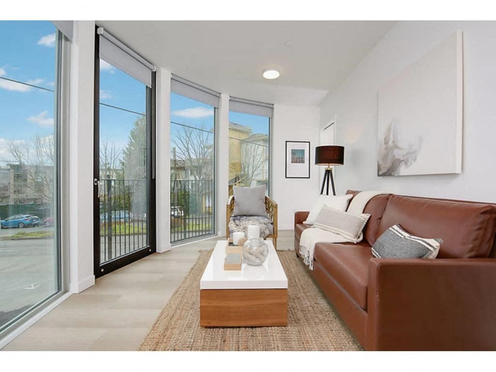 Apartments in Seattle for Rent - Inspire Fremont - Living Room with Hardwood Style Flooring, Glass Door to Private Balcony/Patio, Floor to Ceiling Windows, Overhead Lighting, and Stylish Decor