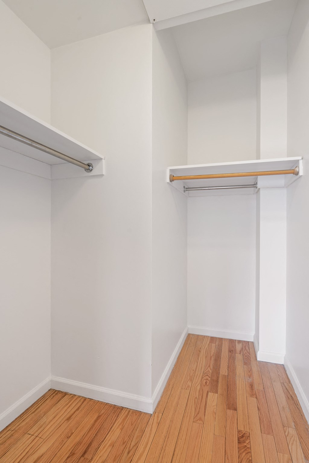 a room with white walls and a wooden floor and two white closets
