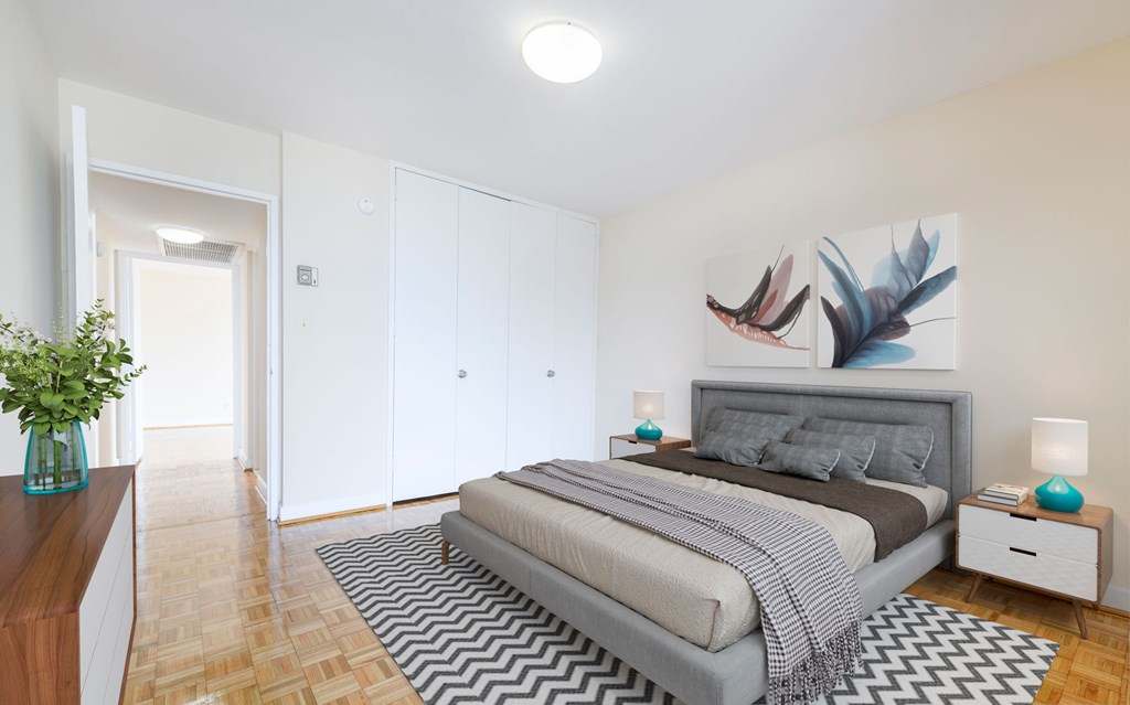 A bedroom with a bed, nightstand, and a painting of a bird on the wall.