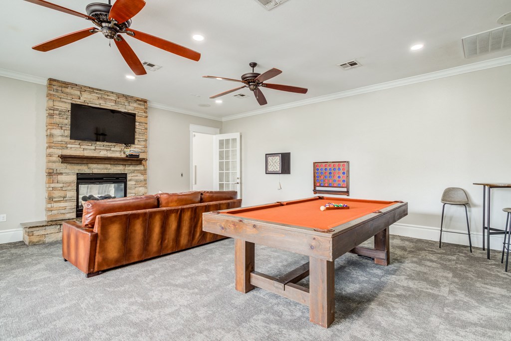 Game room with couch to watch tv and ceiling fan and pool table