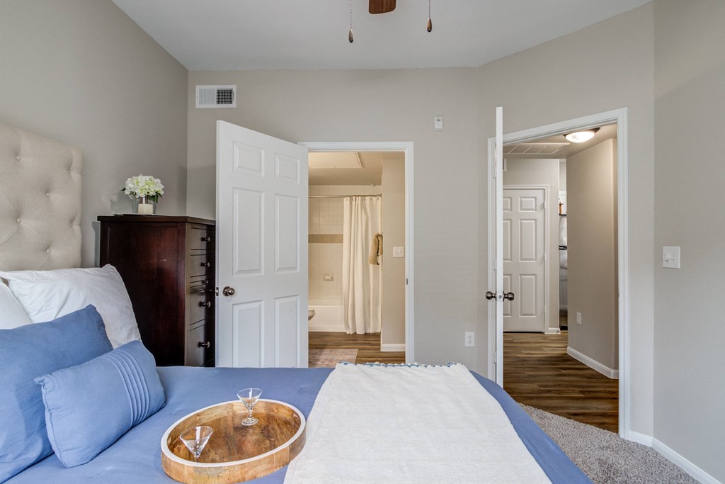 a bedroom with carpet floor and doors and ceiling fan
