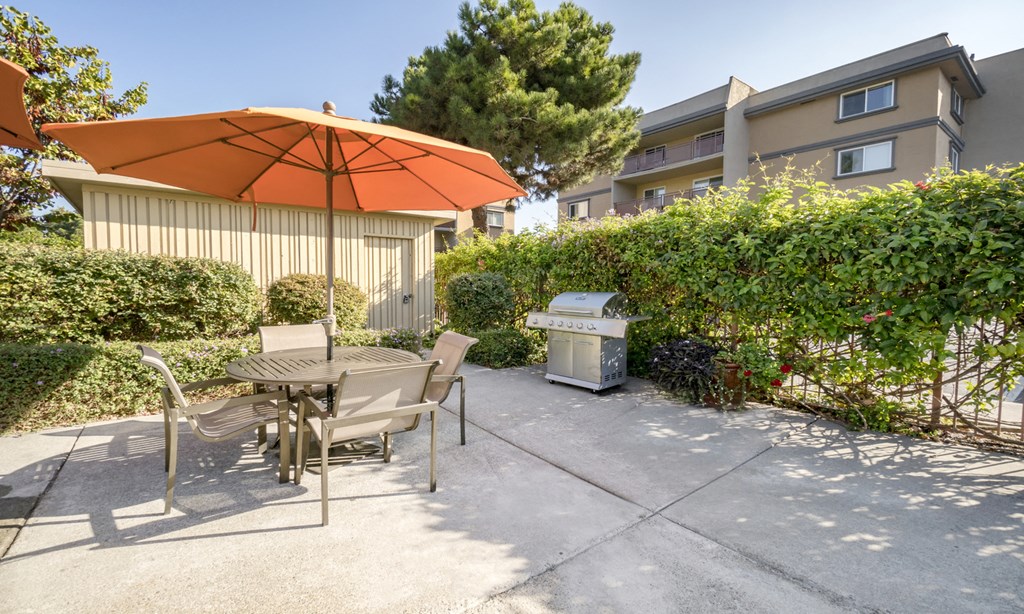 a patio with an umbrella and a table with chairs