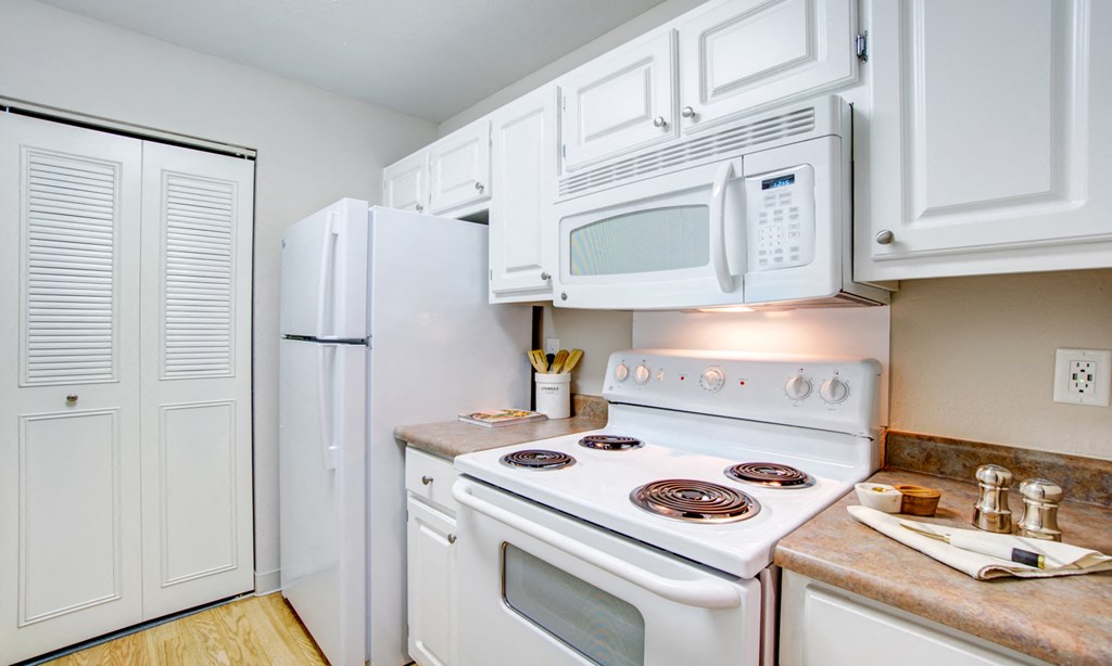 a kitchen with white appliances and white cabinets