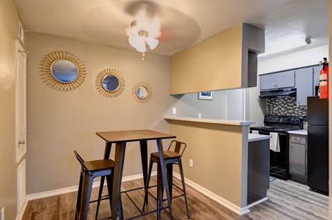 A kitchen with a table and chairs.