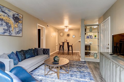 A living room with a white couch and blue chairs.