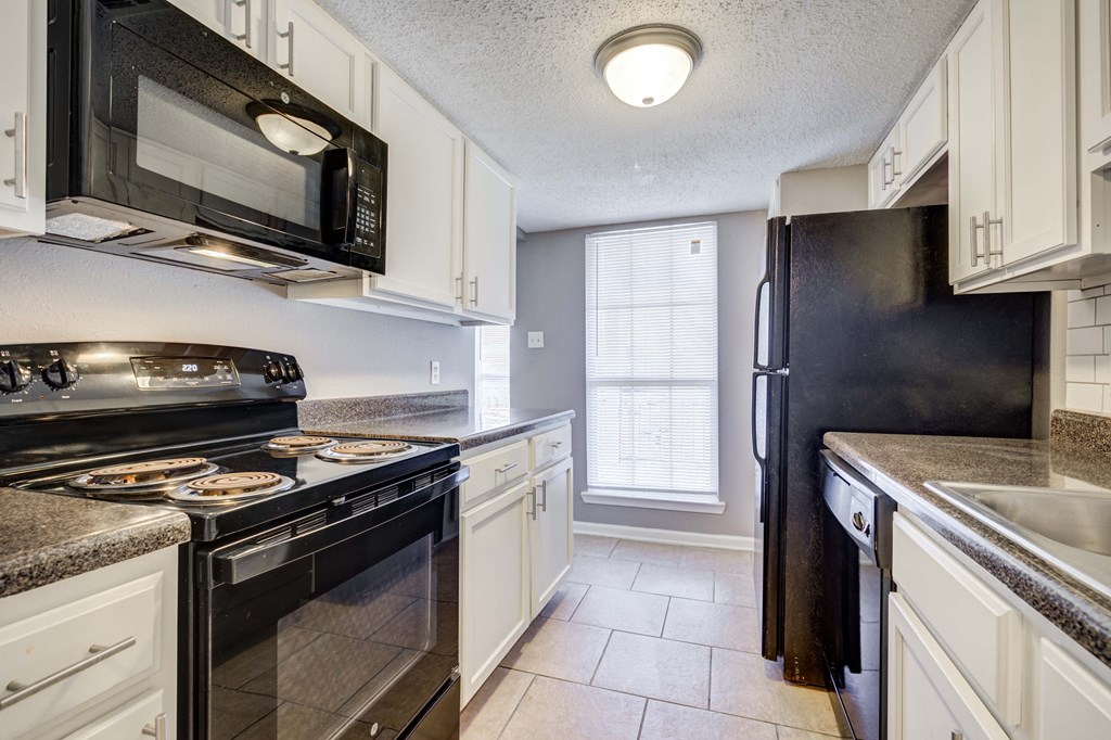 Westchase Apartments in Harvey LA photo of a kitchen with black appliances and white cabinets