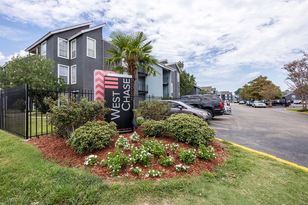 Westchase Apartments in Harvey LA photo of the property's monument sign with flowers