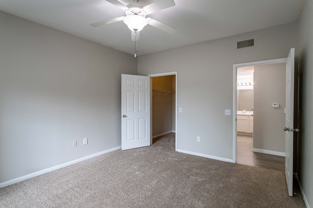 Affordable Houston Texas Apartments – Westchase Forest – Photo of guest bedroom with plush carpet and ceiling fan