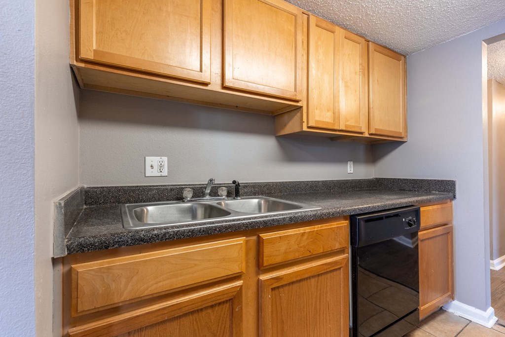 Westchase Apartments in Harvey LA photo of kitchen with black appliances and oak cabinets