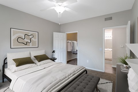 A bedroom with a large bed and a painting on the wall.
