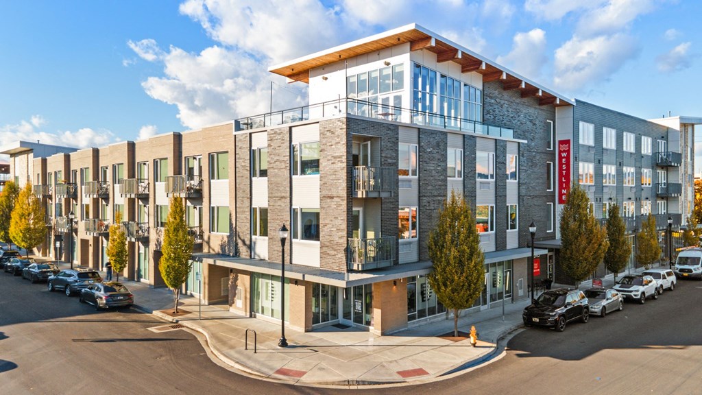 A modern building with a parking lot in front of it.