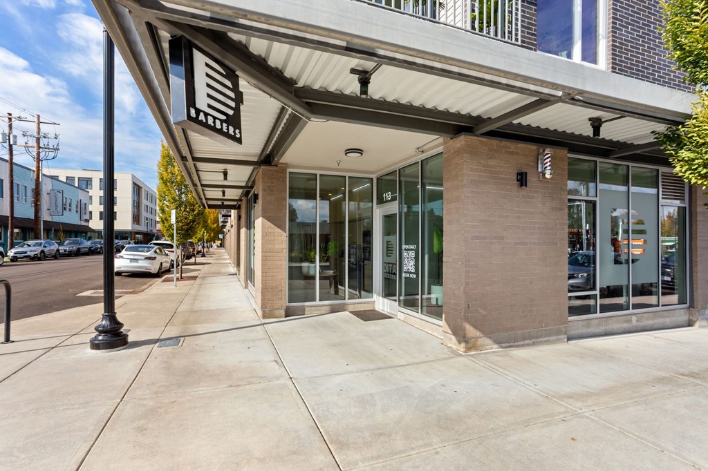 A building with a glass door entrance and a black sign above it.