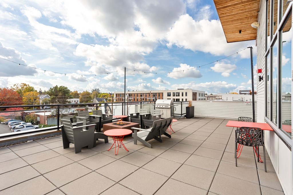 A patio with a table and chairs overlooking a parking lot.
