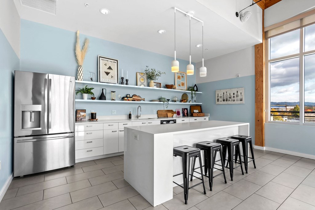 A modern kitchen with a large island and stools.