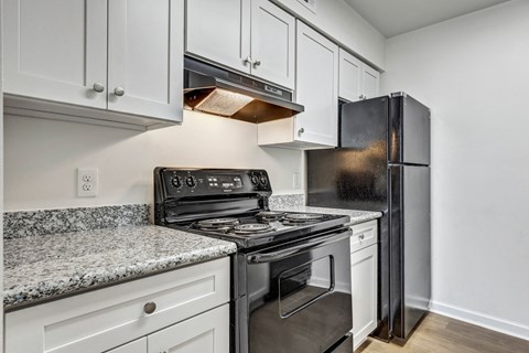 a kitchen with white cabinets and black appliances and granite counter tops