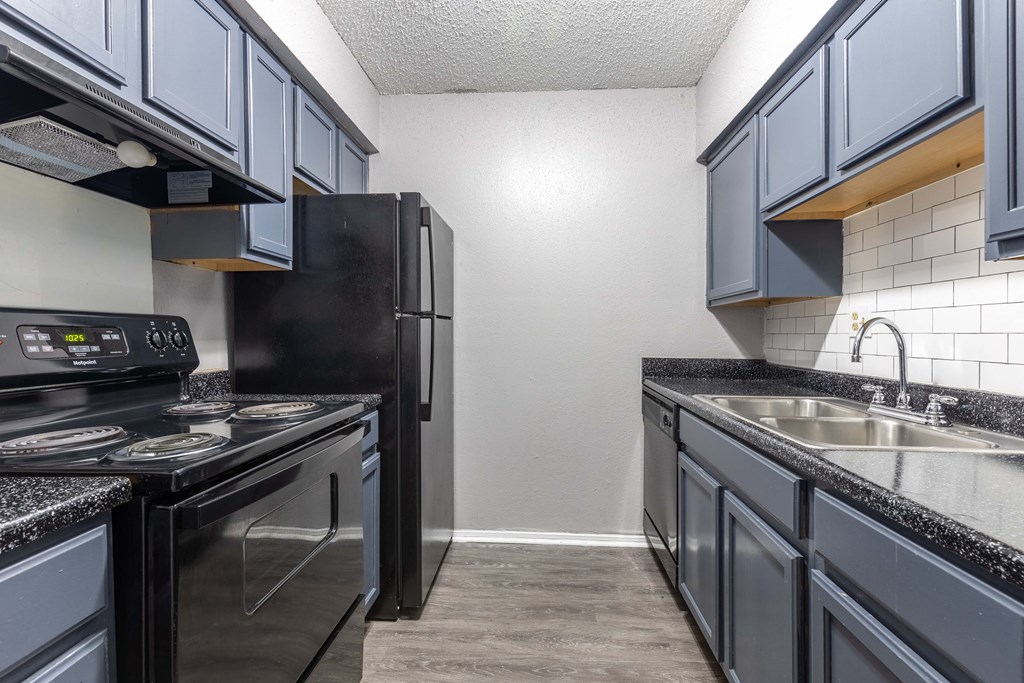 Whitney Manor Apartments in Gretna, LA photo of kitchen with black granite and blue cabinets
