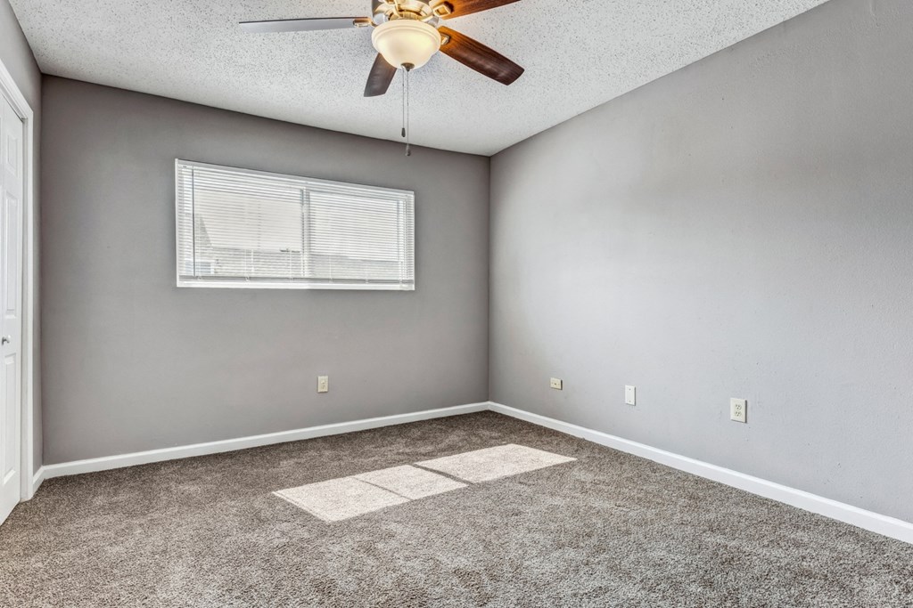 Whitney Manor Apartments in Gretna, LA photo of bedroom with plush carpeting and ceiling fan