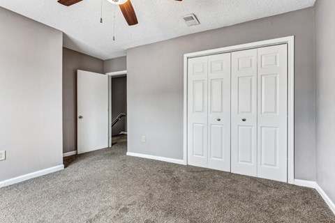 Whitney Manor Apartments in Gretna, LA photo of bedroom with plush carpeting and ceiling fan