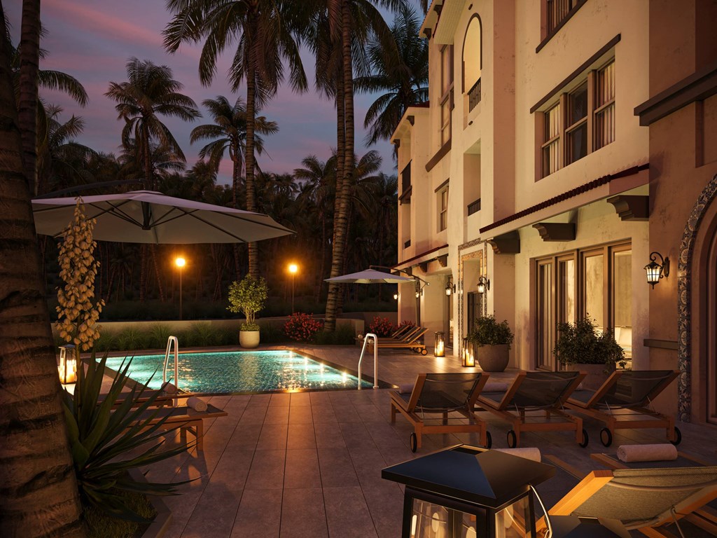 a swimming pool in the evening at a hotel with palm trees