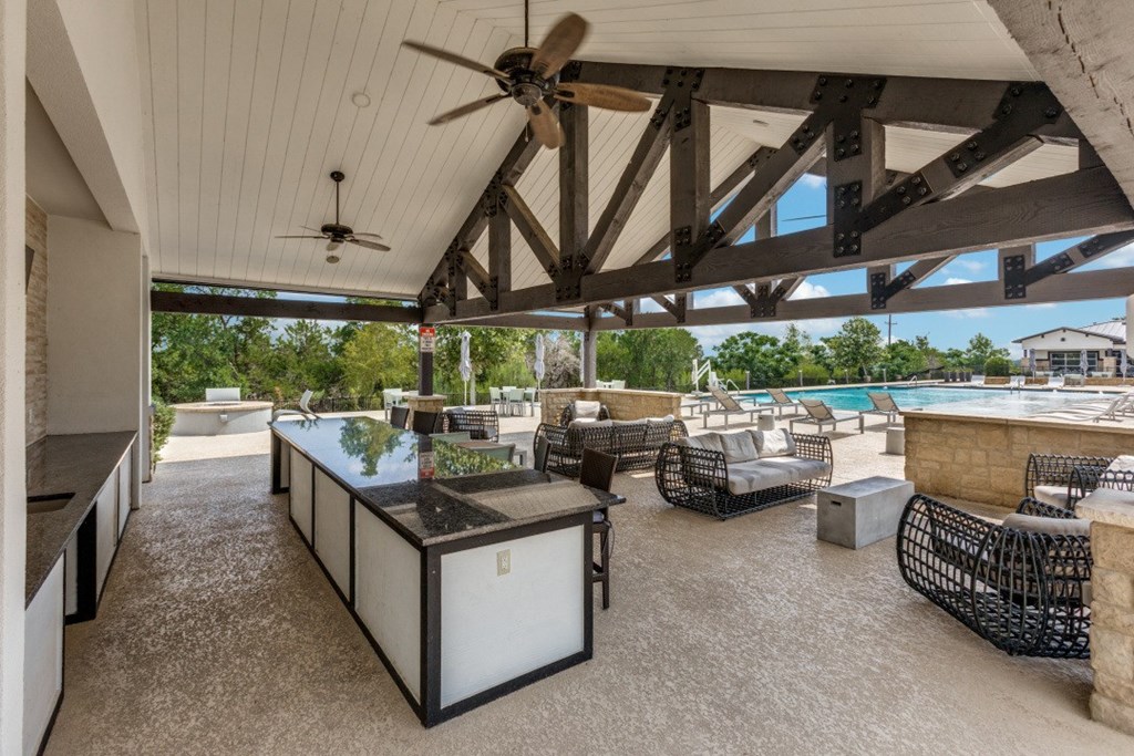 A patio with a table and chairs and a ceiling fan.