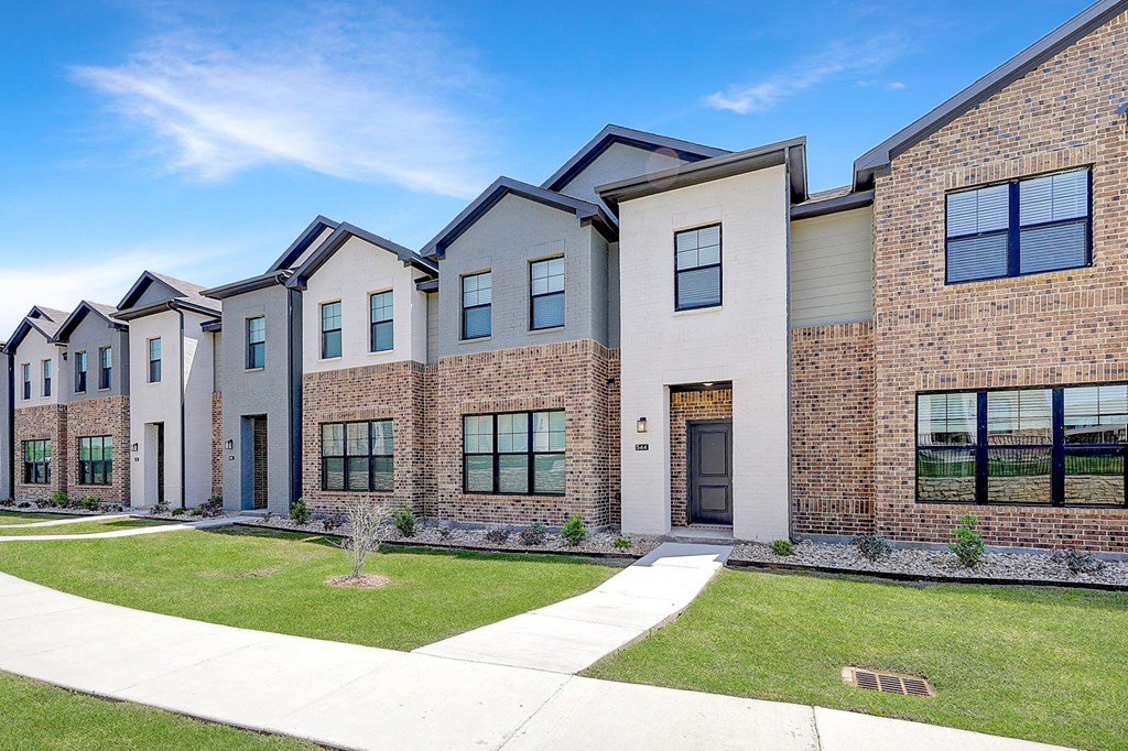Willow Park TX Townhomes - Willow Crossing - An exterior shot of Willow Crossing with grass and a sidewalk